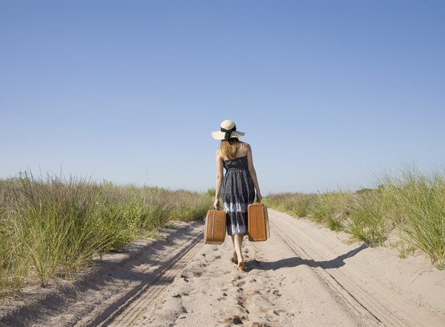 viaggi-donna-valigie-spiaggia_650x478