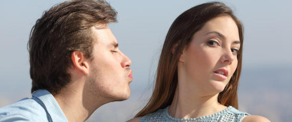 Friend zone concept with a man trying to kiss a woman and she rejecting him