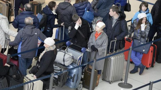 Alcuni passeggeri attendono pazientemente di fare il check in al JFK di New York Alcuni passeggeri attendono pazientemente di fare il check in al JFK di New York
