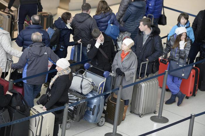 Alcuni passeggeri attendono pazientemente di fare il check in al JFK di New York Alcuni passeggeri attendono pazientemente di fare il check in al JFK di New York