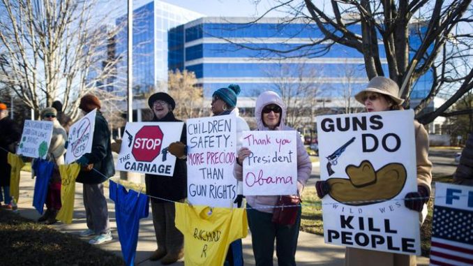 USA: un gruppo di manifestanti sventola cartelli contrari alla vendita delle armi, legale in tutti gli Stati Uniti d'America USA: un gruppo di manifestanti sventola cartelli contrari alla vendita delle armi, legale in tutti gli Stati Uniti d'America