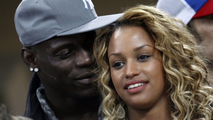 AC Milan's Balotelli talks with his girlfriend, model Fanny Robert Neguesha, as they watch their Champions League soccer match against Barcelona at the San Siro stadium in Milan