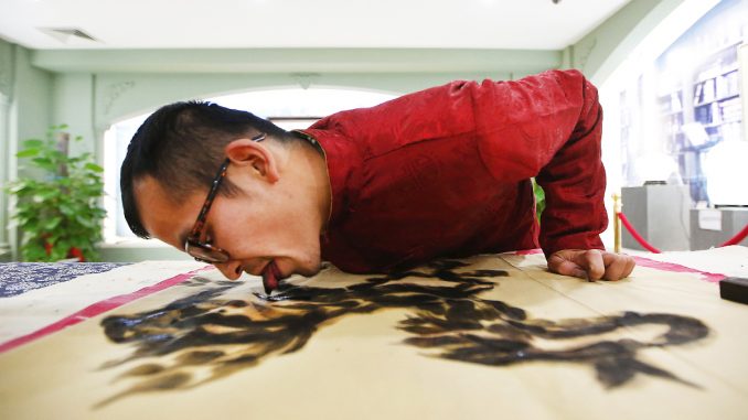 Folk artist Han demonstrates painting with his tongue in Hangzhou