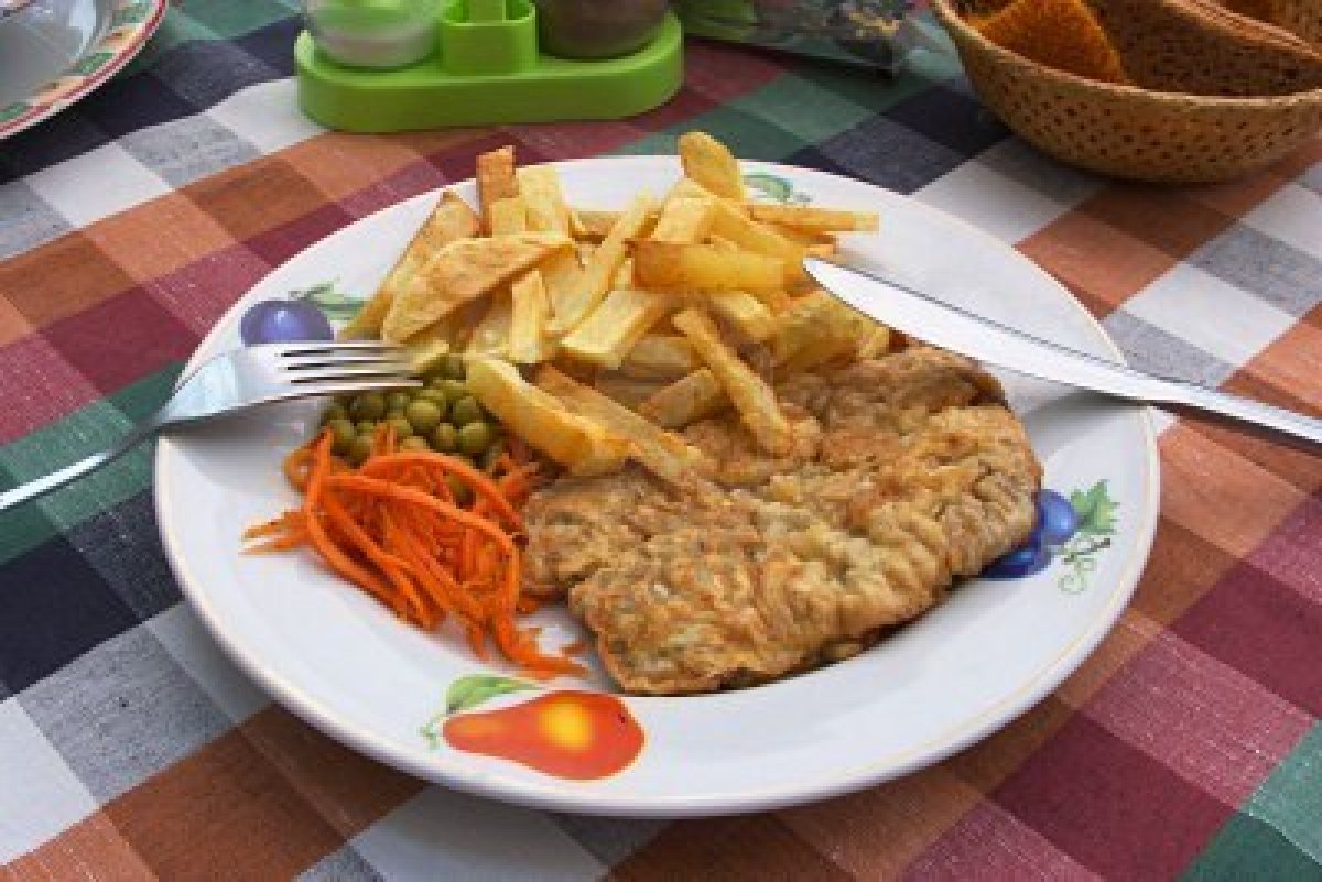 991383 cotoletta di pollo patatine fritte e verdure su un piatto una forchetta e un coltello