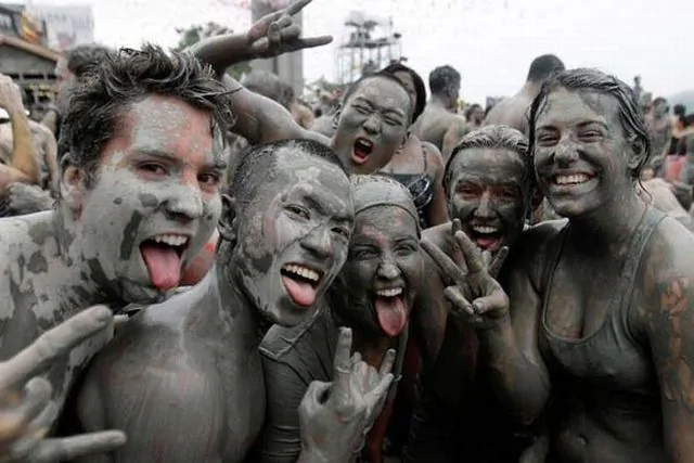 Foreign tourists covered in mud during the Boryeong Mud Festival.