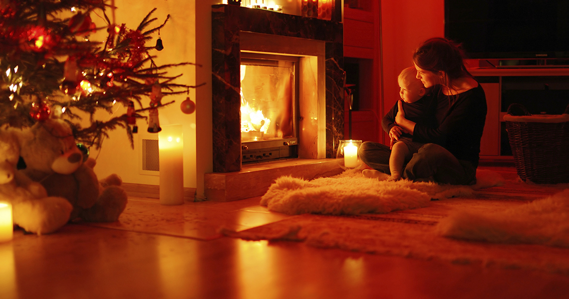 Young mother and her daughter by a fireplace