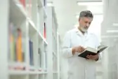 9906812 rinomato scienziato medico in una biblioteca di ricerca centro ospedale un libro di navigazione