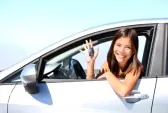 9981818 donna di conducente di auto asiatiche sorridente mostrando le auto e le chiavi della macchina nuova
