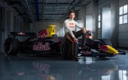 Max Verstappen, il pilota da Record, posa seduto sopra la sua vettura sponsorizzata Redbull