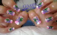 Nail art con fiori fai da te fiori lilla su fondo bianco e rosa con pois