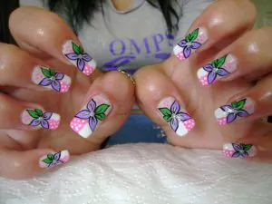 Nail art con fiori fai da te fiori lilla su fondo bianco e rosa con pois