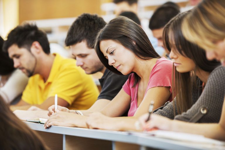 Large group of students writing.