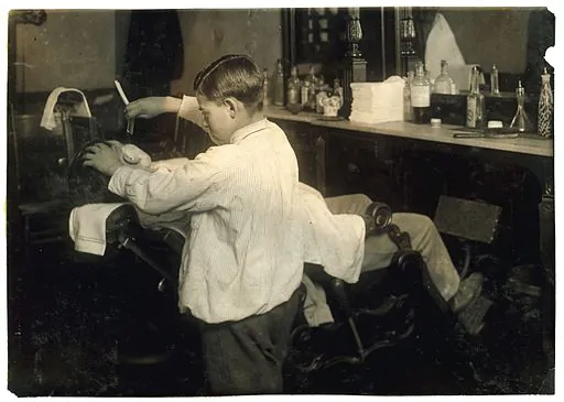 Lewis_Hine,_Frank_De_Natale,_12-year_old_barber,_Boston,_1917