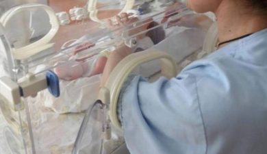 Infermiera con bimbo in incubatrice
