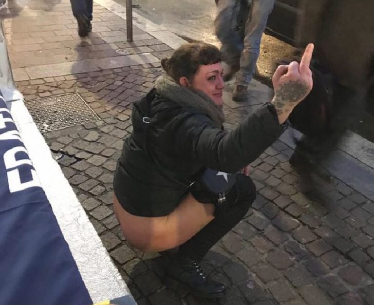 Elezioni 2018, a Milano ragazza urina in pubblico sulla bandiera di Fdi