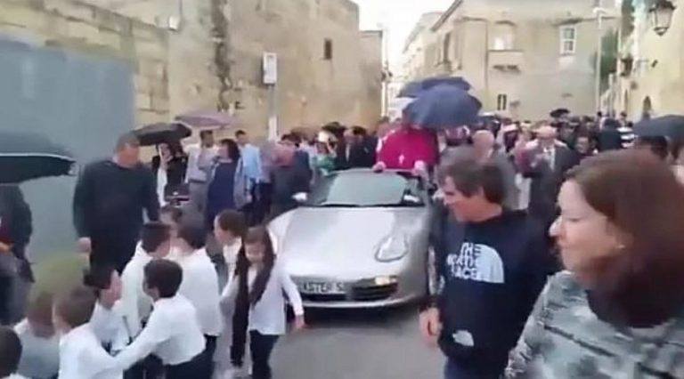 Arcivescovo su una Porsche trainata da 50 bambini