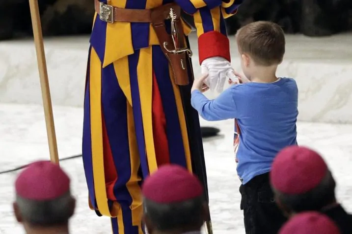 bambino sale sul palco durante l'udienza del Papa