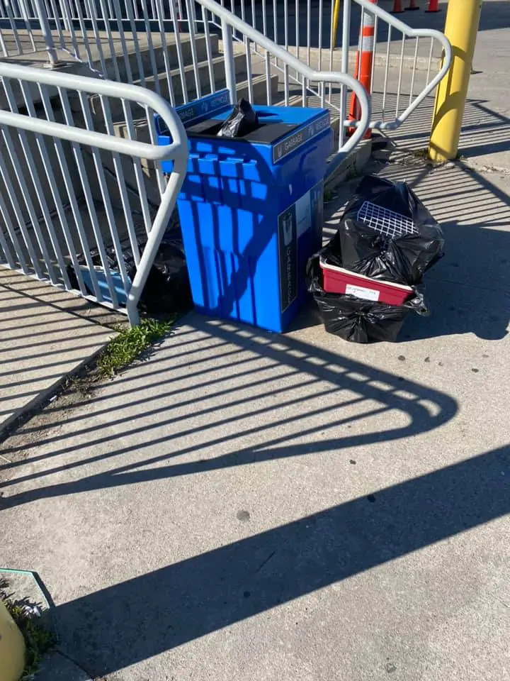 La gabbia accanto un bidone della spazzatura