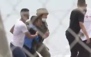 Un migrante aiutato da un soldato a Ceuta