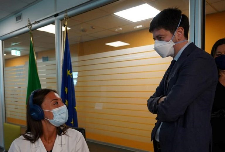 Il ministro Speranza mentre parla con un'operatrice della sanità