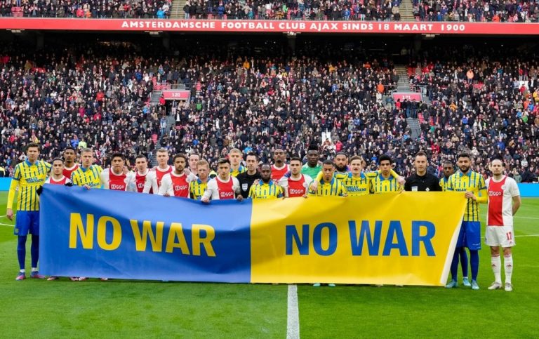 Le formazioni di Ajax e Shakhtar con uno striscione contro la guerra