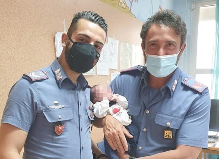 Il piccolo con i suoi due salvatori in divisa