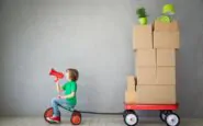 caricatura del trasloco con il bambino che trasporta i pacchi con il triciclo
